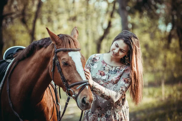 Chica joven con un caballo en el bosque . — Foto de Stock