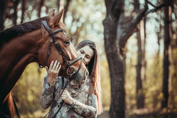 Jovem com um cavalo na floresta . — Fotografia de Stock