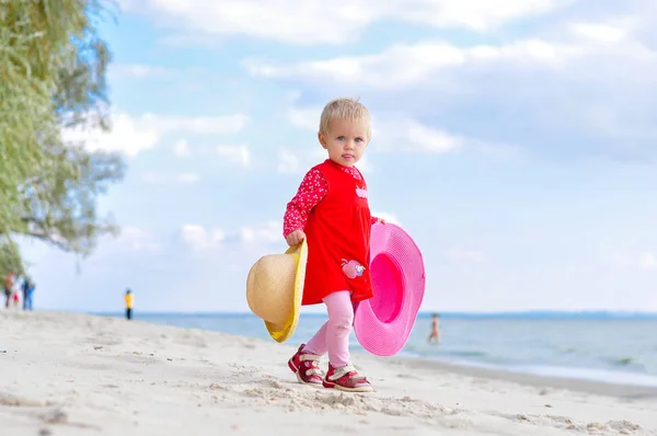 Kleines Mädchen mit Hut am Strand — Stockfoto