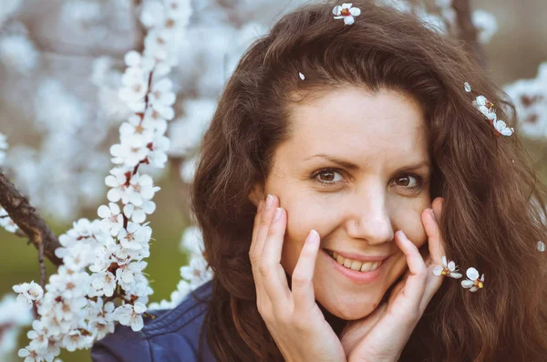 Menina fica perto de uma árvore de floração — Fotografia de Stock