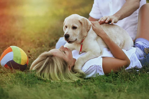 Blondin leker med en labrador. — Stockfoto