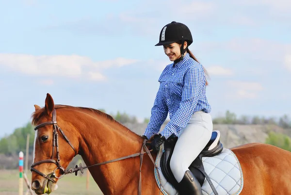 A girl jockey rides a horse