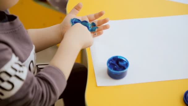 Ребенок рисует рукой краской — стоковое видео