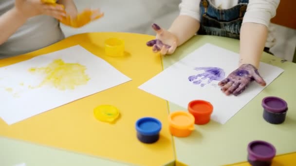 El niño pinta su mano con pintura — Vídeos de Stock