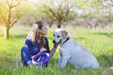 Sarışın bir labrador ile yürüyor