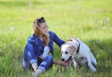 Sarışın bir labrador ile yürüyor