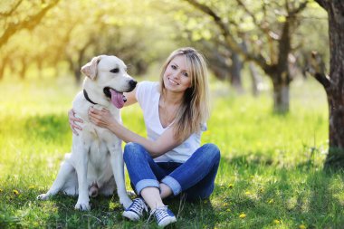 Sarışın bir labrador ile yürüyor