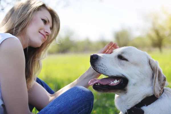 Sarışın bir labrador ile yürüyor