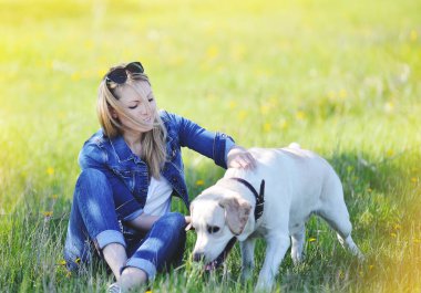 Sarışın çimlerde labrador ile oynuyor
