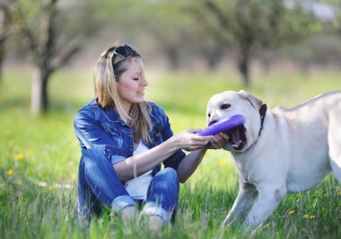 Sarışın çimlerde labrador ile oynuyor