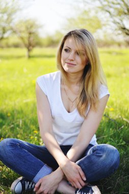 Bir sarışın parkta baharda dinleniyor.