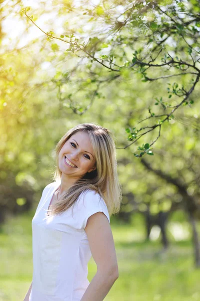 Blondine geht im Frühling im Park spazieren. — Stockfoto