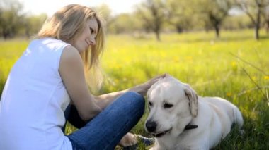 Sarışın bir labrador ile oynuyor.