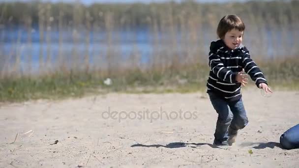 Kid met moeder zeepbellen spelen op het strand — Stockvideo