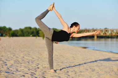 Kız sahilde asanas yapıyor