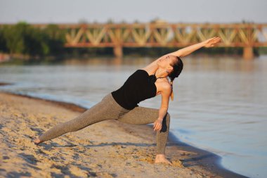 Kız sahilde asanas yapıyor