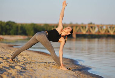 Kız sahilde asanas yapıyor