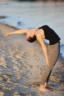 Kız sahilde asanas yapıyor