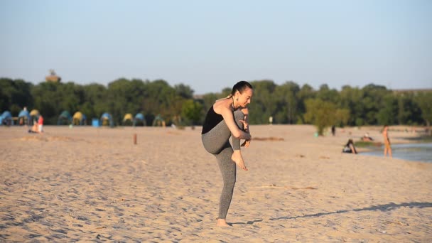 做体式在海滩上的女孩 — 图库视频影像