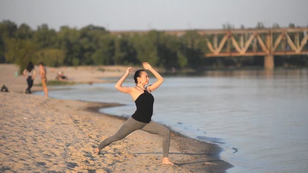 Flicka gör asanas på stranden — Stockvideo