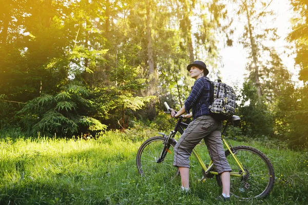 La chica está montando una bicicleta en el bosque — Foto de Stock