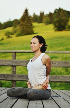 Dağlarda yoga yapan bir kadın.