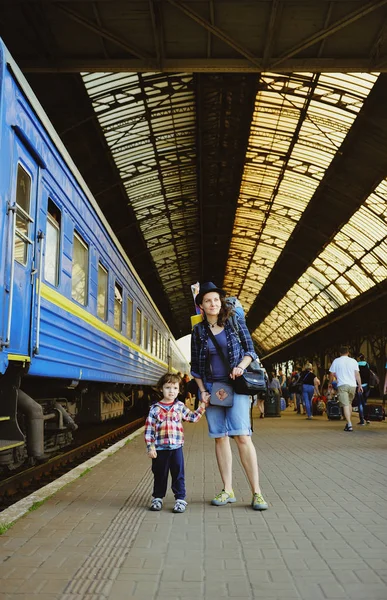 Mamá y el bebé están de pie cerca del tren —  Fotos de Stock