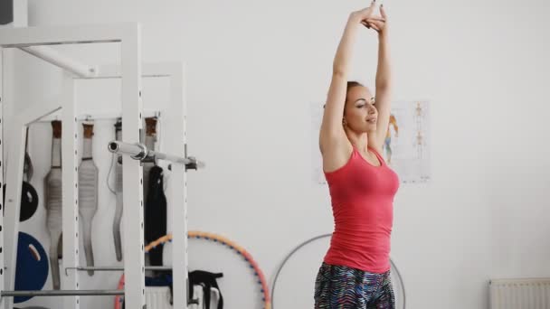 Mooie jonge vrouw houdt zich bezig met Turnen in de sportschool. — Stockvideo