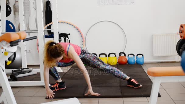 Mooie jonge vrouw houdt zich bezig met Turnen in de sportschool. — Stockvideo