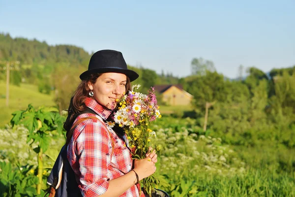 山の散歩のための野生の花の花束を持って女の子 — ストック写真