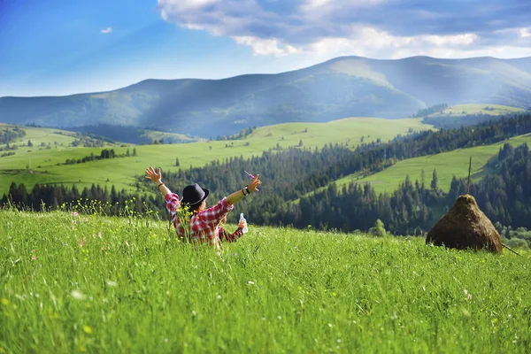 Dağlarda bir çayırda onu genç oğlu ile yaz aylarında oturan genç anne.