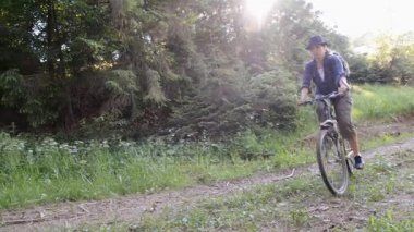 Ormandaki dağlarda bisiklet süren genç bir kadın. Dağ bisikleti.