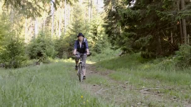 Ormandaki dağlarda bisiklet süren genç bir kadın. Dağ bisikleti. — Stok video