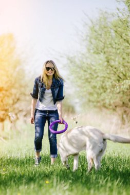 Sarışın bir labrador ile oynuyor.