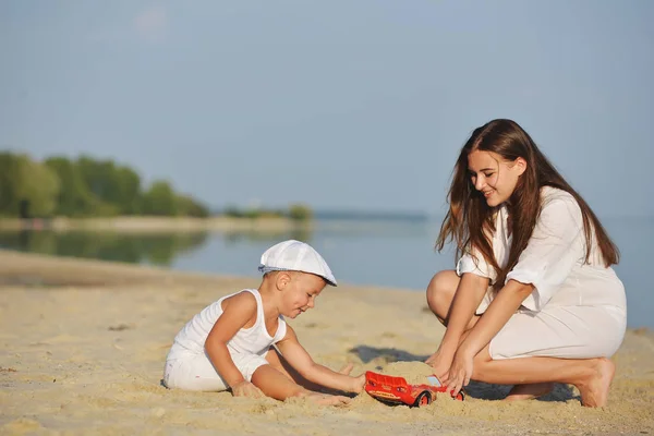 Mama spielt mit dem Baby im Sommer am Strand — Stockfoto