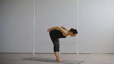 Genç bir kadın sonbahar sabahı parkta yoga yapıyor..