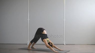 Genç bir kadın sonbahar sabahı parkta yoga yapıyor..