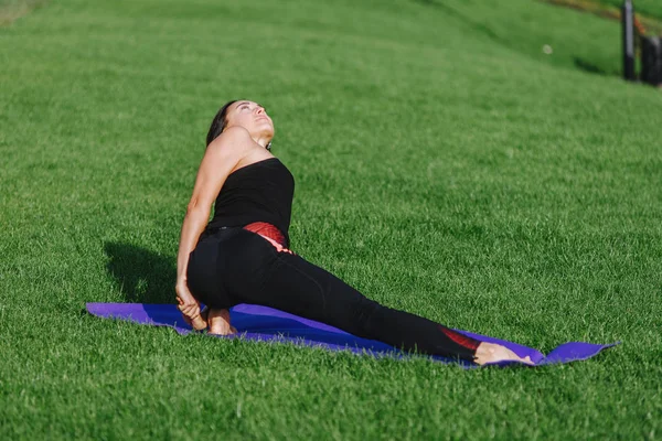genç kadın sonbaharda sabah parkta yoga yaparken.