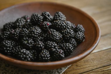 Blackberry bir seramik kase ahşap bir masaya yatıyor.