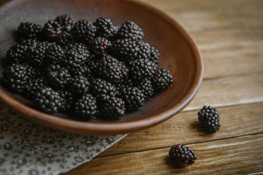 Blackberry bir seramik kase ahşap bir masaya yatıyor.