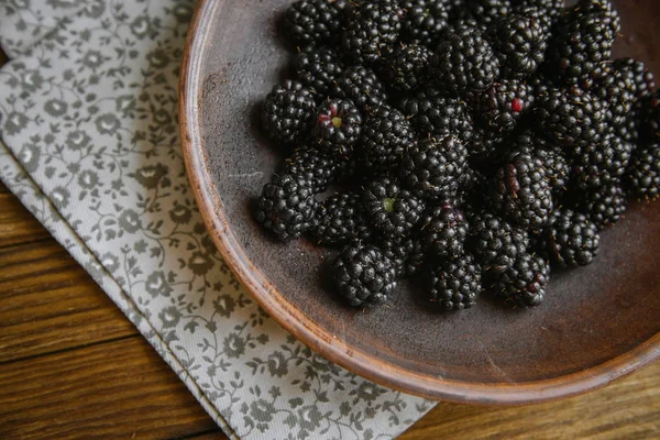 Blackberry bir seramik kase ahşap bir masaya yatıyor.