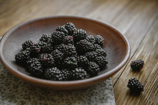 Blackberry bir seramik kase ahşap bir masaya yatıyor.