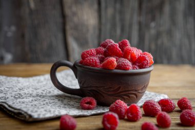 kahverengi seramik mug ahududu ile ahşap bir masa üzerinde duran