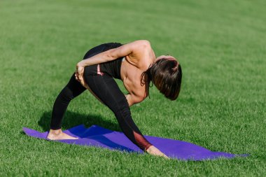 genç kadın sonbaharda sabah parkta yoga yaparken.