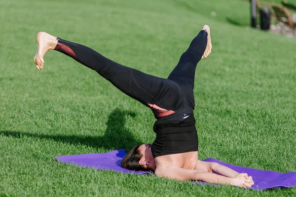 genç kadın sonbaharda sabah parkta yoga yaparken.