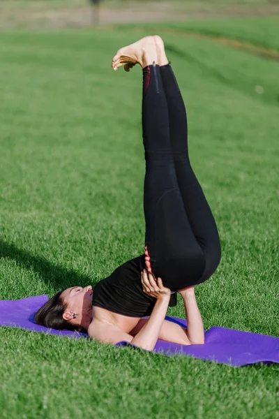 genç kadın sonbaharda sabah parkta yoga yaparken.