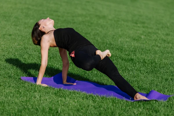genç kadın sonbaharda sabah parkta yoga yaparken.