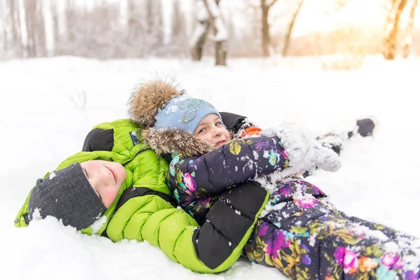 Niños, hermanos y hermanas jugando en la nieve en el invierno en el parque — Foto de Stock