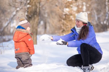 kadın parkta bir kış için küçük bir çocukla yürümek.