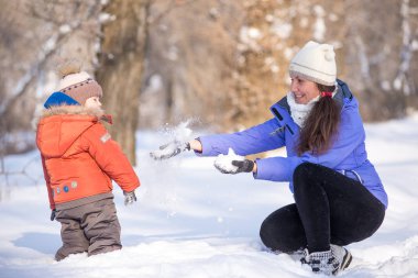 kadın parkta bir kış için küçük bir çocukla yürümek.